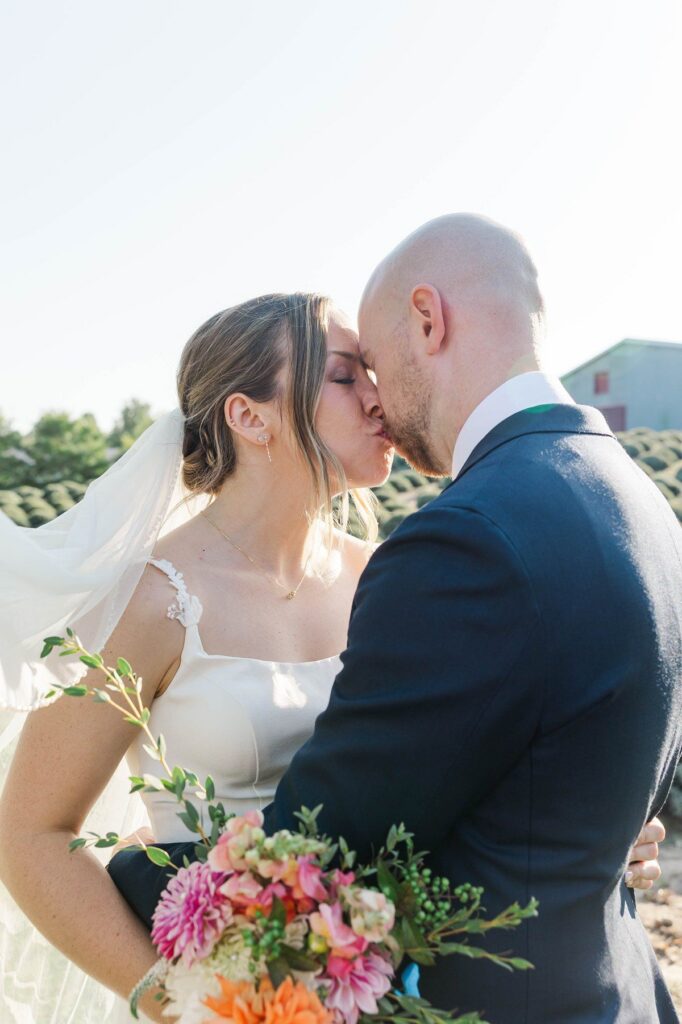Bride and groom sharing a kiss after their Lavender Hill Farm wedding ceremony