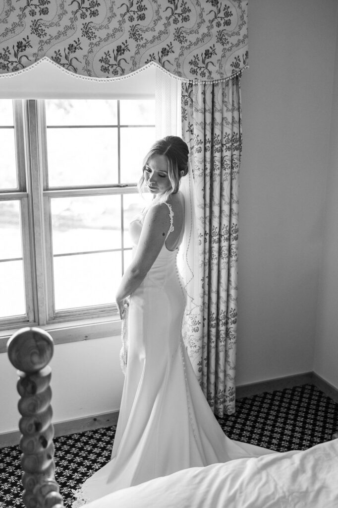 Bride by the window getting ready before her Lavender Hill Farm wedding at Boyne Mountain Resort