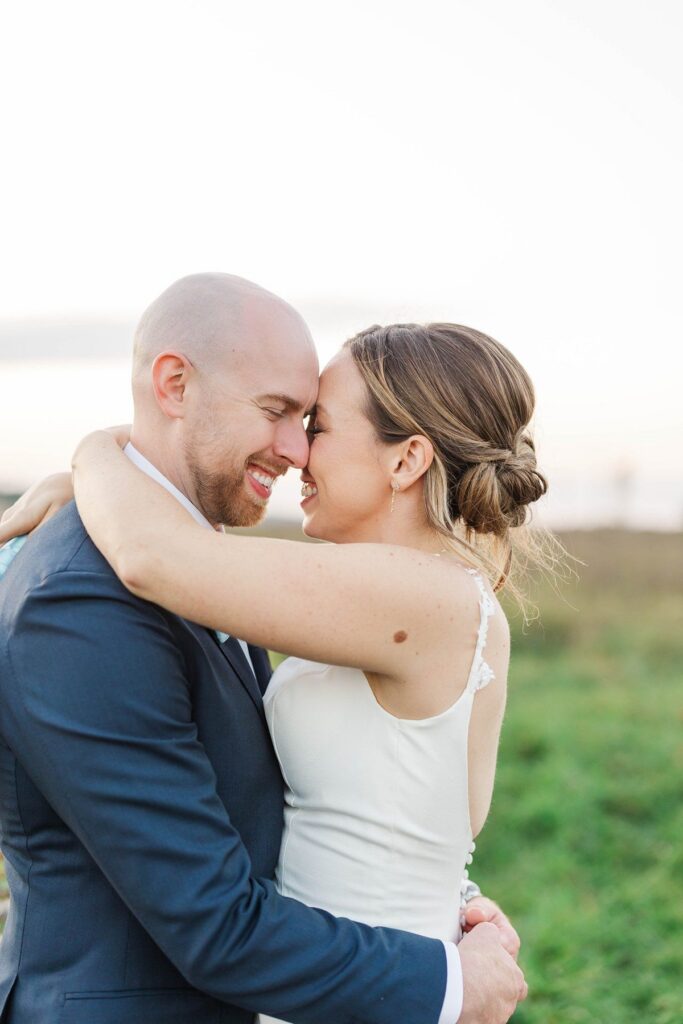 Bride and groom embracing in the cosmos flower field at Lavender Hill Farm