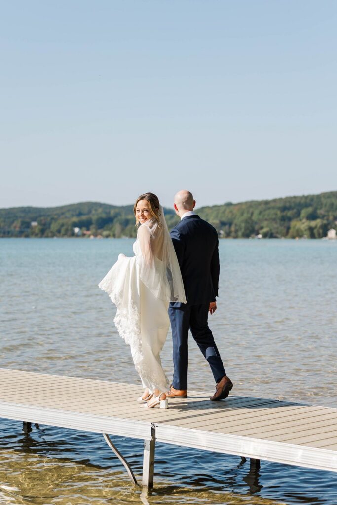 Bride looking back while walking on the Deer Lake dock before her Lavender Hill Farm wedding