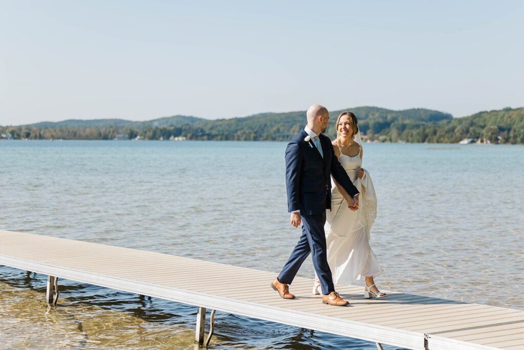 Bride and groom walking together on the dock at Deer Lake before their Lavender Hill Farm wedding
