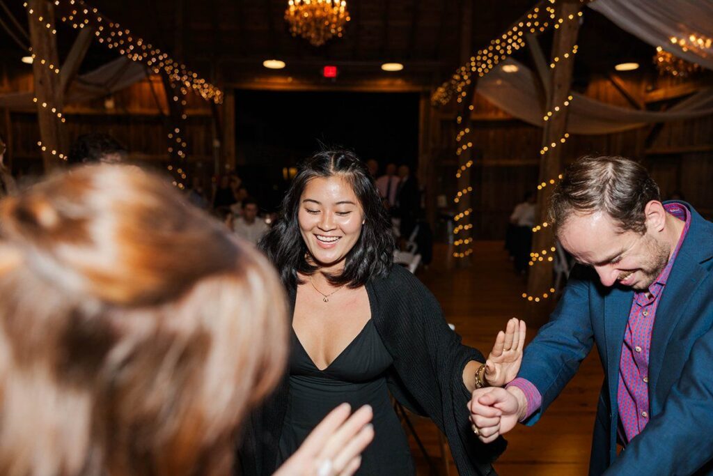 Wedding guests dancing at the reception inside Lavender Hill Farm's barn