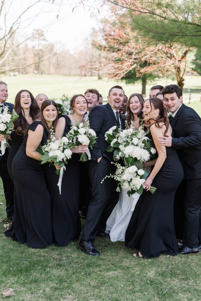 Madison and Jaxon laughing with their wedding party during portraits at Mill Pond Event Center.