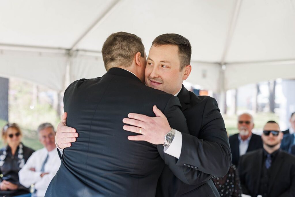 Jaxon sharing a hug with his brother Jakob before the ceremony at their Mill Pond Event Center wedding in Kalkaska, Michigan.