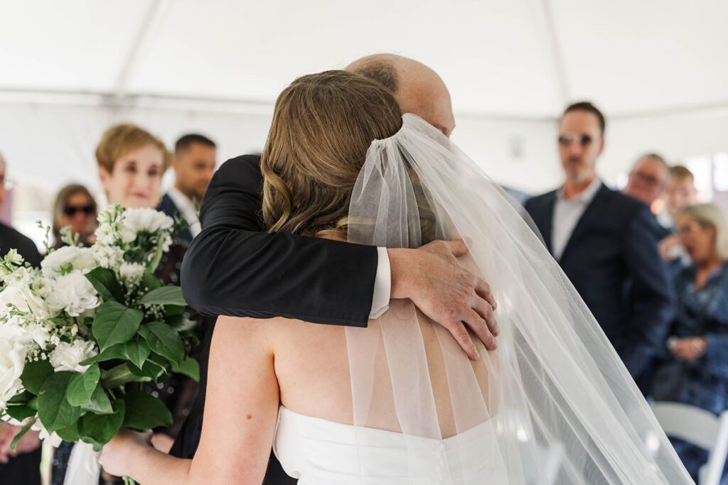Madison sharing an emotional hug with her dad during her Northern Michigan wedding at Mill Pond Event Center in Kalkaska, Michigan.