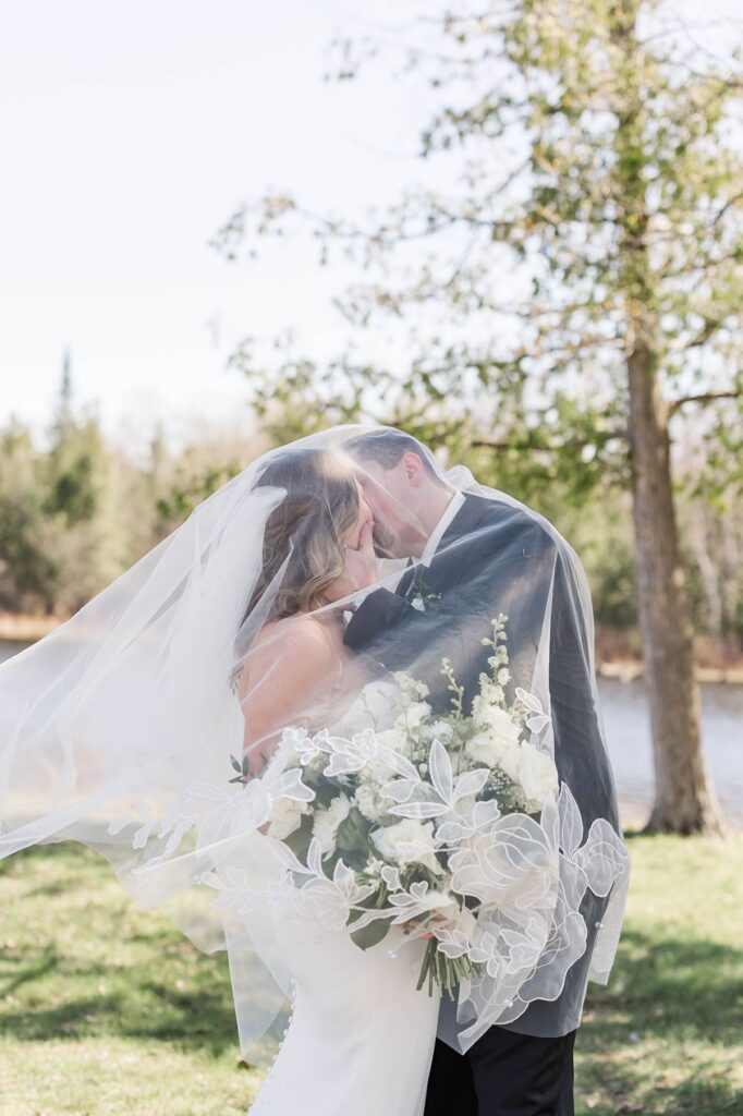 Bride and groom sharing a romantic veil portrait during their Northern Michigan wedding at Mill Pond Event Center.