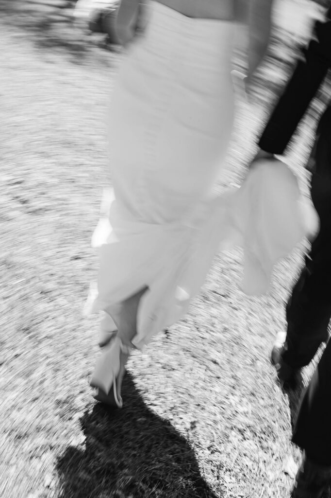 Documentary-style motion blur of Madison and Jaxon walking hand in hand after portraits at their Mill Pond Event Center wedding in Kalkaska, Michigan.