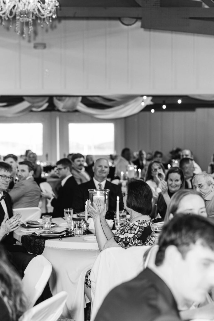 Wedding guests reacting during heartfelt reception speeches at Madison and Jaxon's Mill Pond Event Center wedding in Kalkaska, Michigan.