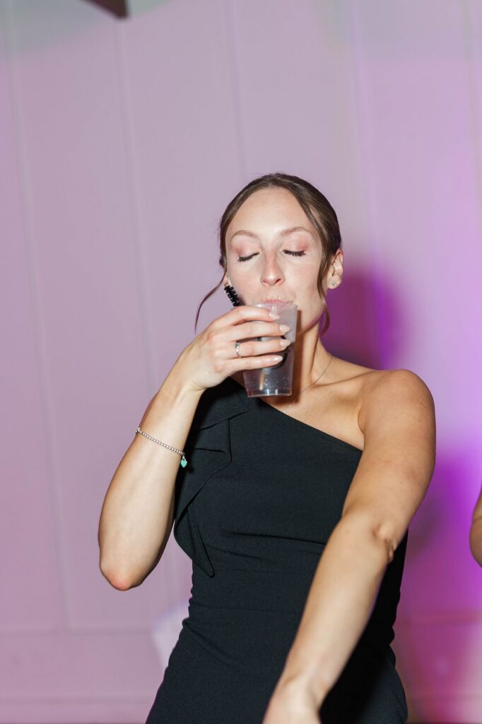 Candid direct-flash photo of a wedding guest enjoying the dance floor during Madison and Jaxon’s Mill Pond Event Center reception.