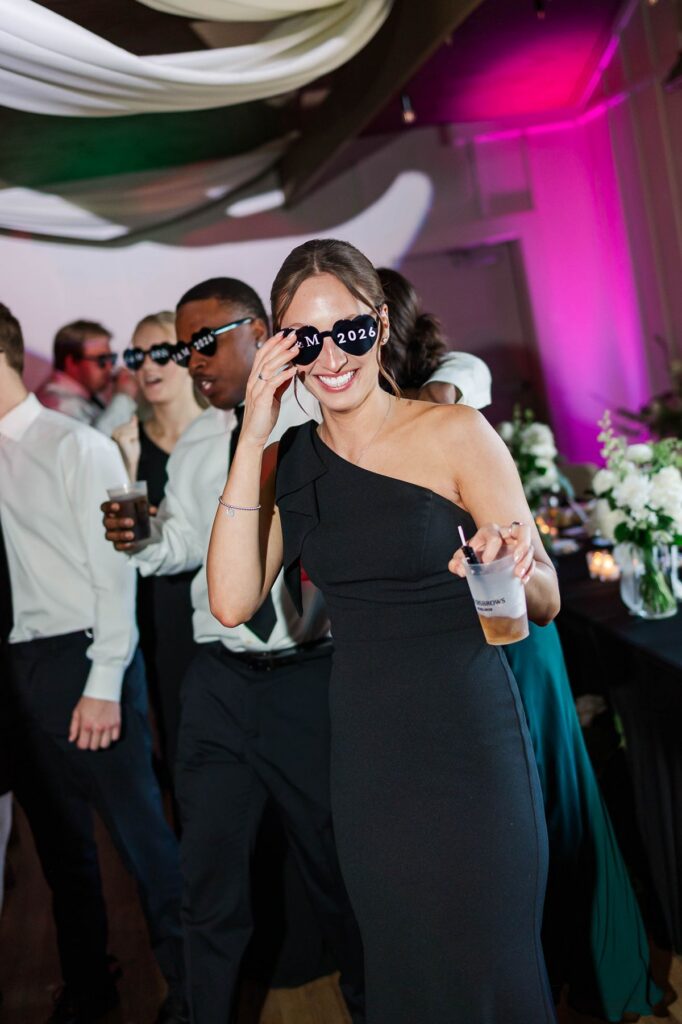 Candid direct-flash dance floor photo of wedding guests celebrating during Madison and Jaxon's Mill Pond Event Center reception in Kalkaska, Michigan.