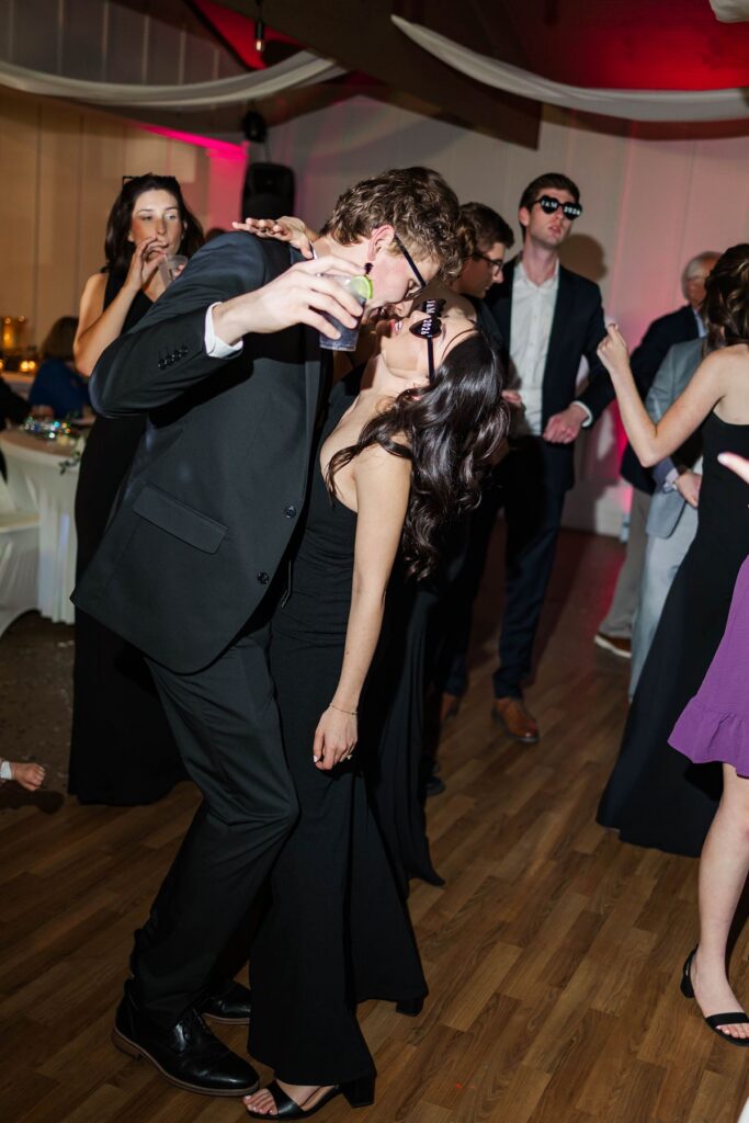 Candid direct-flash dance floor photo of wedding guests celebrating during Madison and Jaxon's Mill Pond Event Center reception in Kalkaska, Michigan.