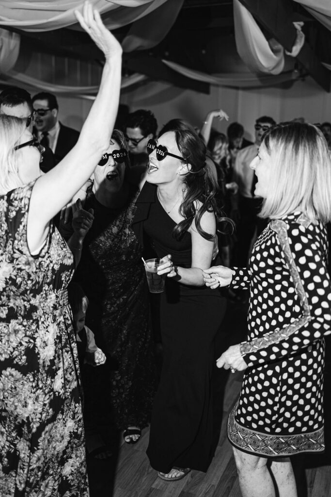 Candid black-and-white dance floor photo during Madison and Jaxon's wedding reception at Mill Pond Event Center in Northern Michigan.