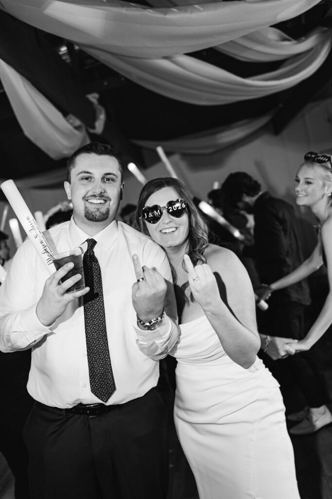 Madison celebrating with a wedding guest on the dance floor during her Mill Pond Event Center wedding reception in Kalkaska, Michigan.