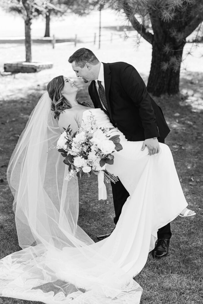 Bride and groom sharing a joyful portrait during their Mill Pond Event Center wedding in Northern Michigan.