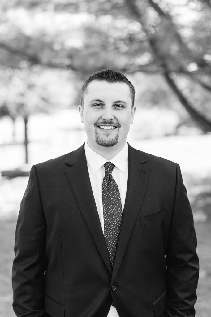 Groom smiling during portraits before his Mill Pond Event Center wedding in Kalkaska, Michigan.