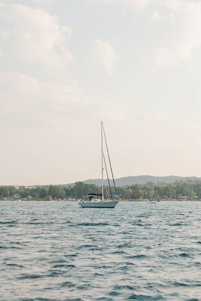 Sailboat gliding across Grand Traverse Bay at sunset in Traverse City