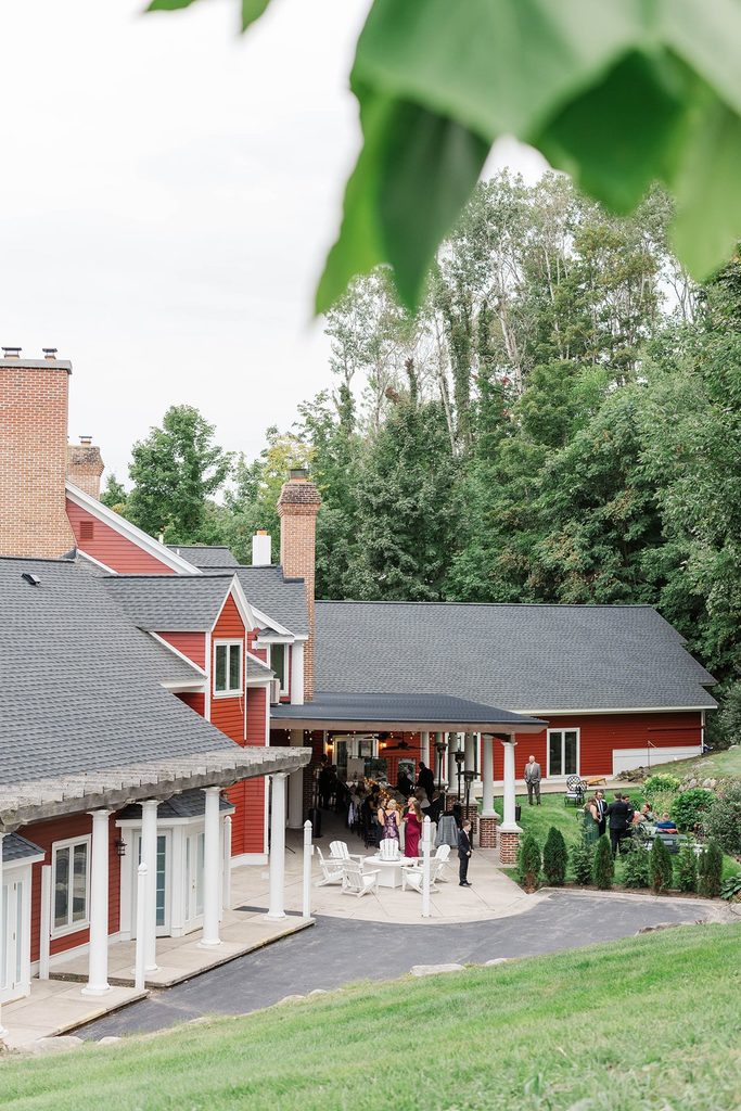 The Inn at Black Star Farms in Suttons Bay, Michigan, featuring its red exterior, covered patio, and surrounding greenery.