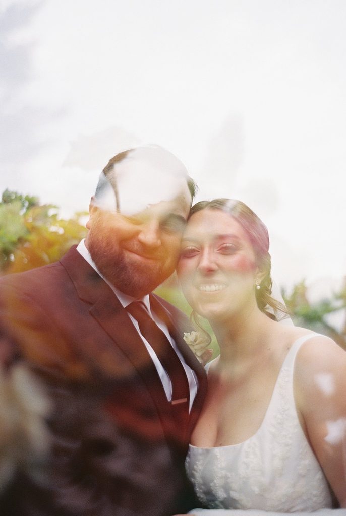 Creative double-exposure film photograph of Allison and Cole, blending their wedding portrait with natural textures at Black Star Farms in Suttons Bay, Michigan.