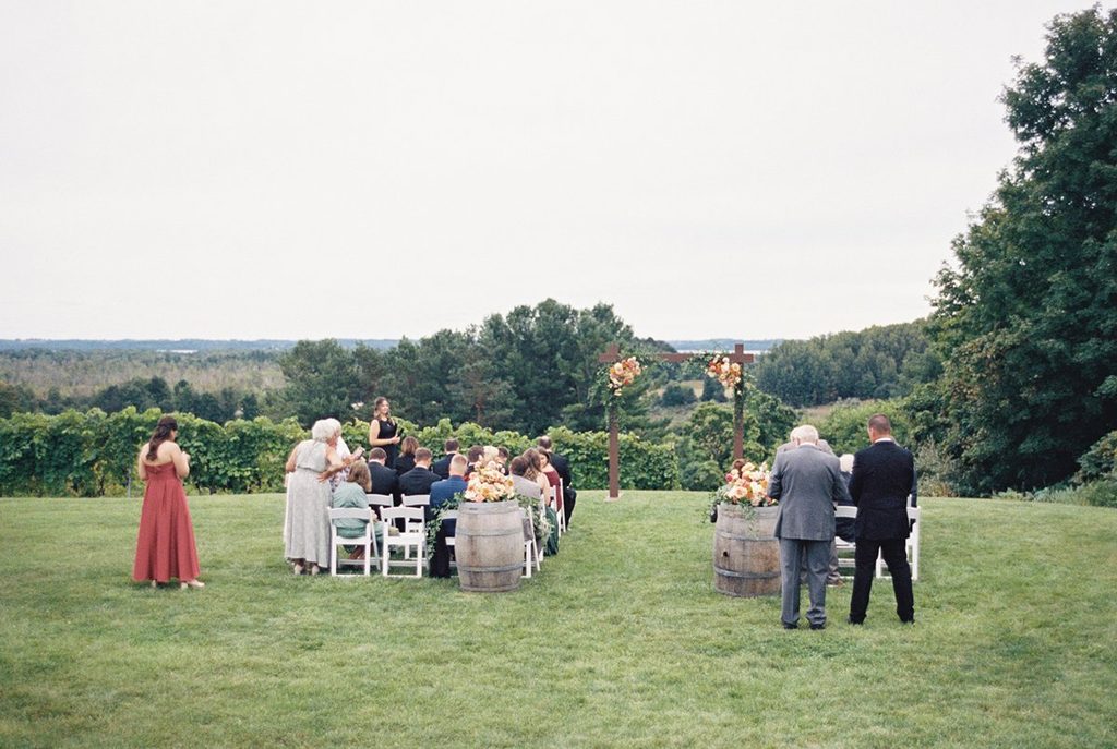 Guests gathering at the outdoor vineyard ceremony site at Black Star Farms in Suttons Bay, Northern Michigan, before Allison and Cole's intimate wedding ceremony.