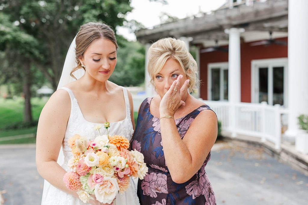 Allison standing beside her emotional mother as she wipes away tears during a special moment before the wedding ceremony at Black Star Farms.