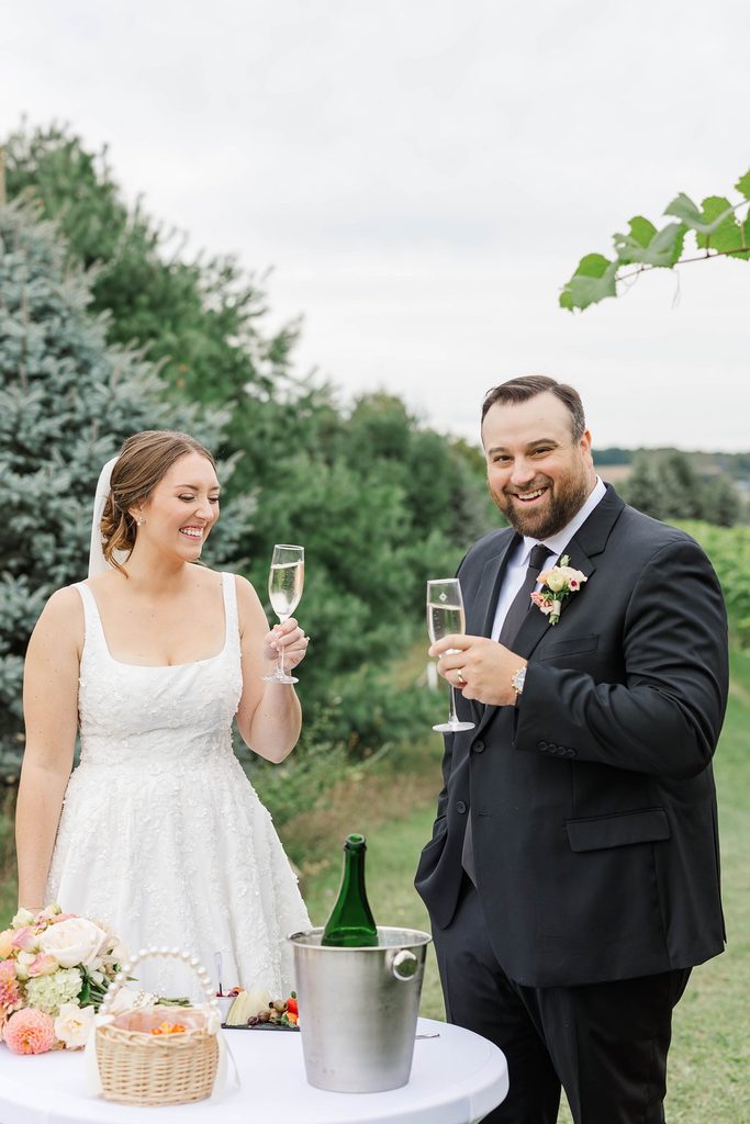 Allison and Cole celebrate with a glass of wine following their intimate wedding ceremony at Black Star Farms winery in Northern Michigan.