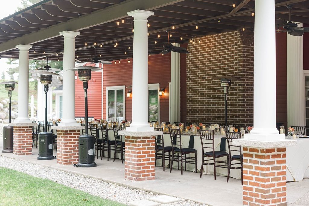Exterior view of the covered patio at Black Star Farms in Suttons Bay, Michigan, decorated for Allison and Cole's intimate wedding reception.