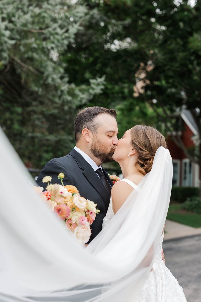 Close-up of Allison and Cole sharing a kiss during their wedding portraits outside the Black Star Farms Inn in Suttons Bay.